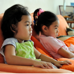 8 Ans Enfant Regarder La Télévision Fixant Sur Un Tapis Blanc Seul