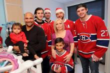 Mila (gauche) et son frère Lohan (centre) sourient avec maman, papa et les joueurs des Canadiens de Montréal. 
